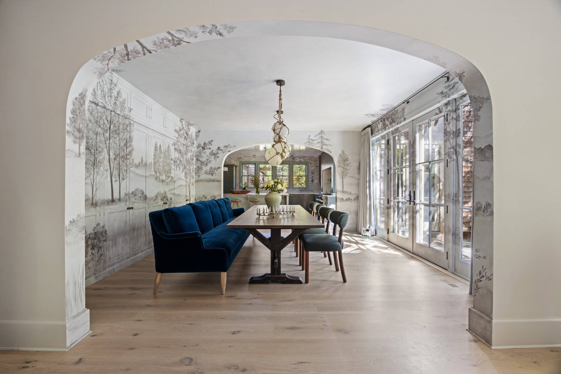 dining room with unique light fixtures and wallpaper with tree motif