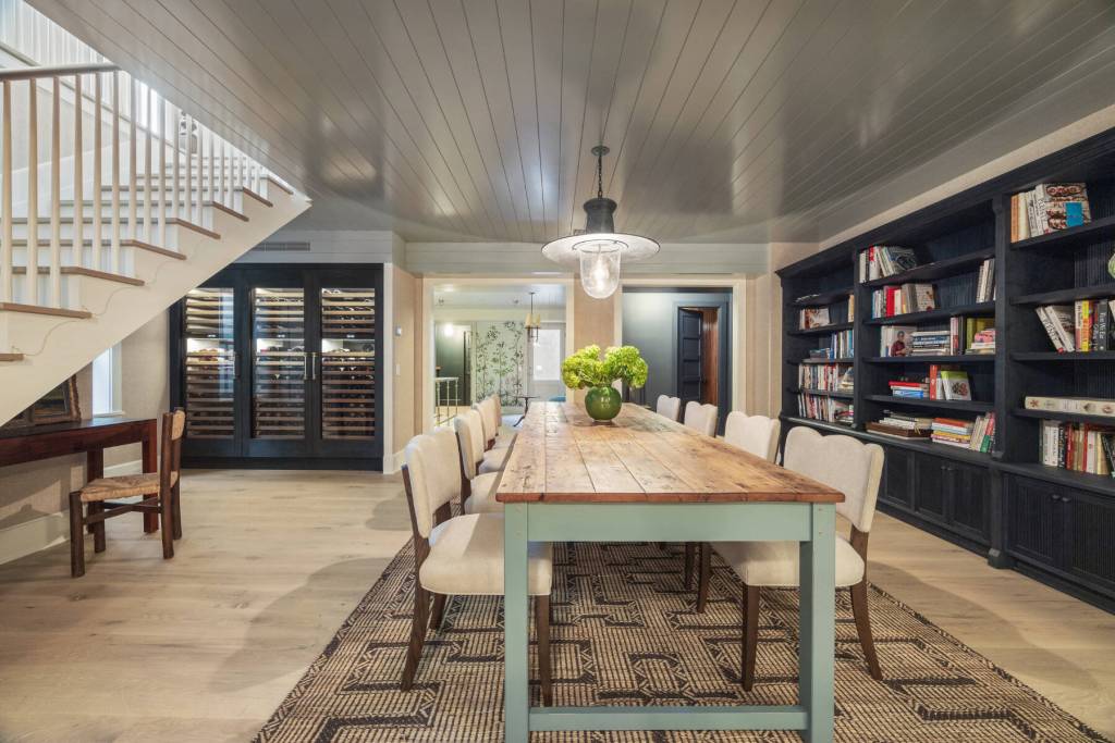 long dining table with bookshelves and wine chiller in the background