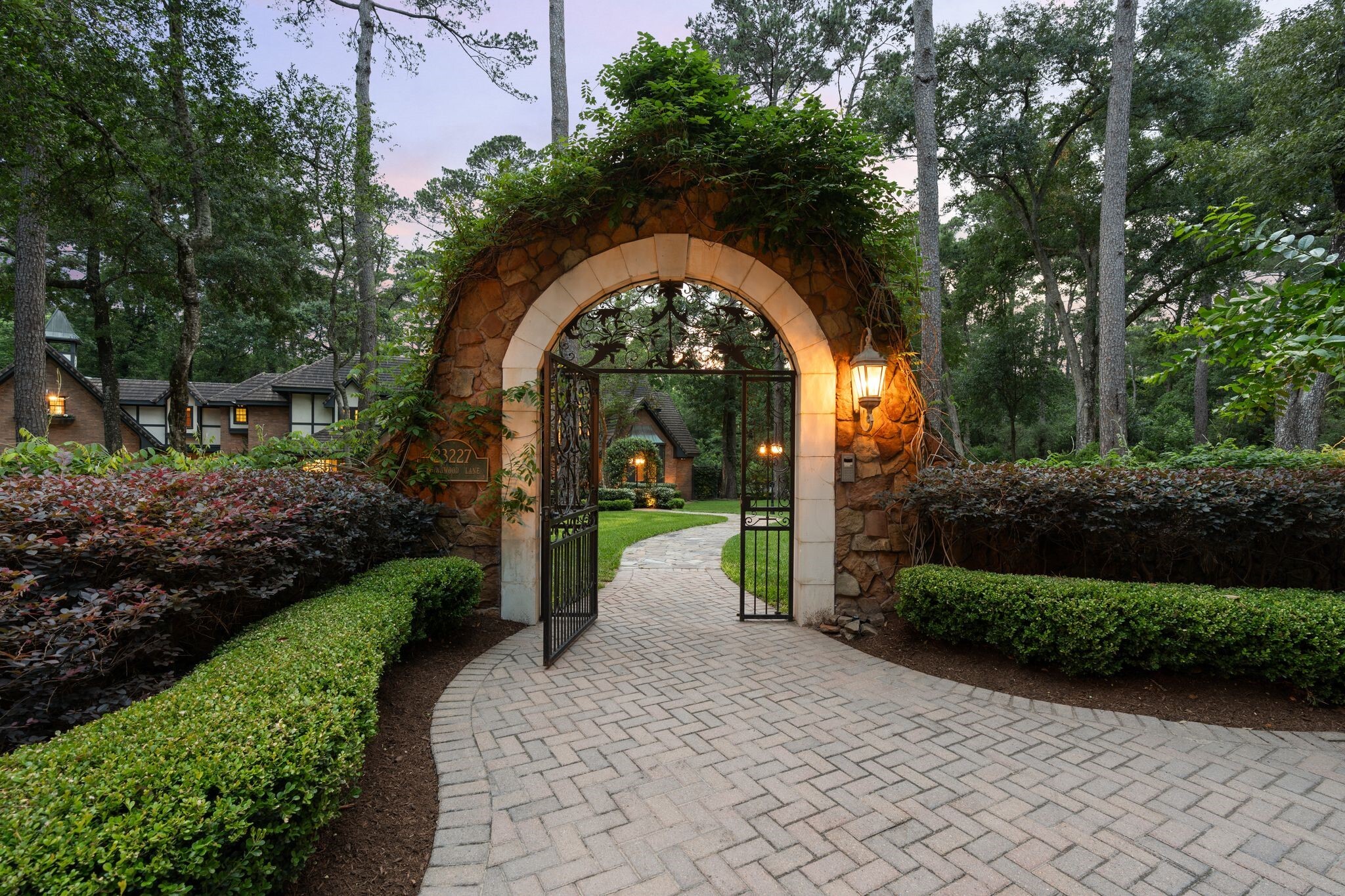 stone archway with gate leading to Tudor-style home in Texas