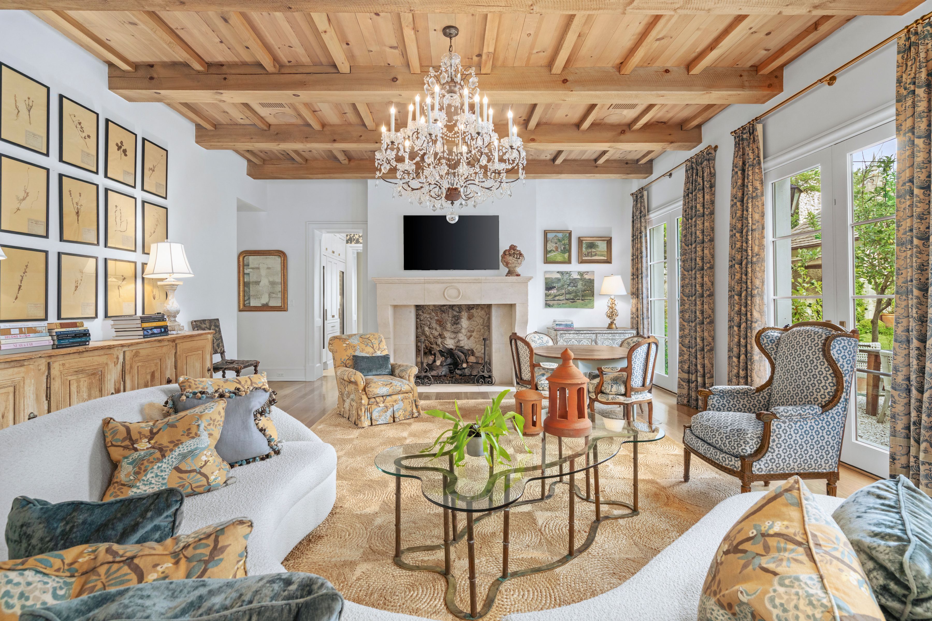 sitting room with limestone fireplace, custom millwork, and and ornate chandelier