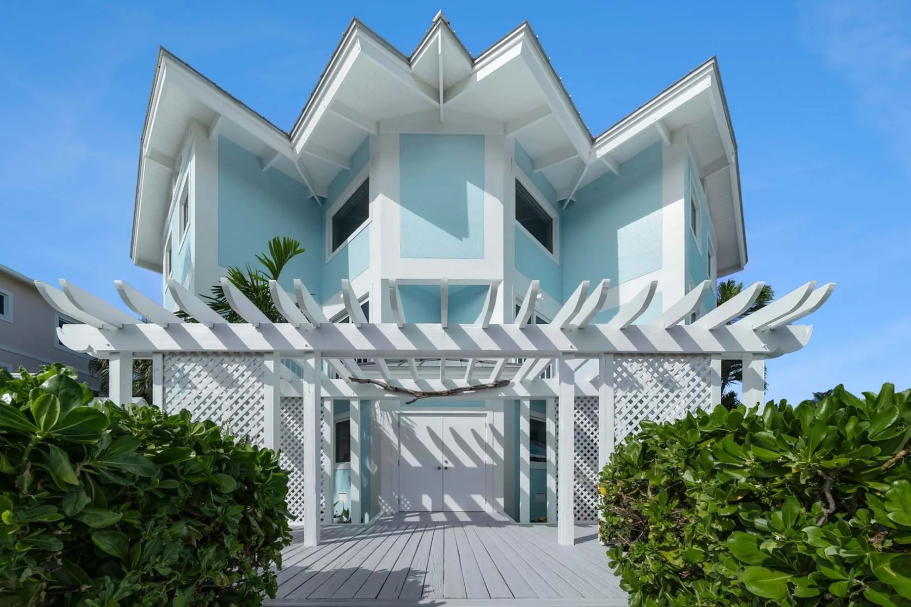 exterior of home in Florida with trellis and turquoise stucco