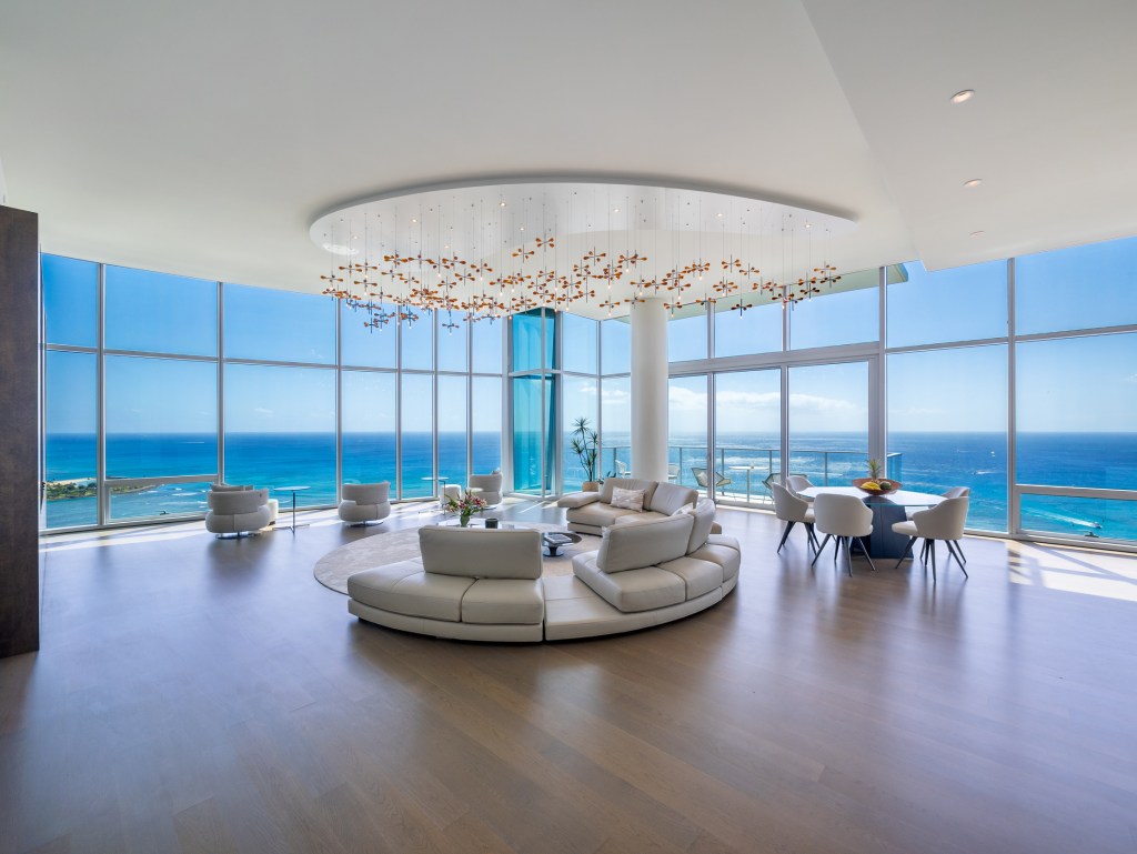 Contemporary living room in a home in Honolulu, Hawaii i with glass walls and ocean views.