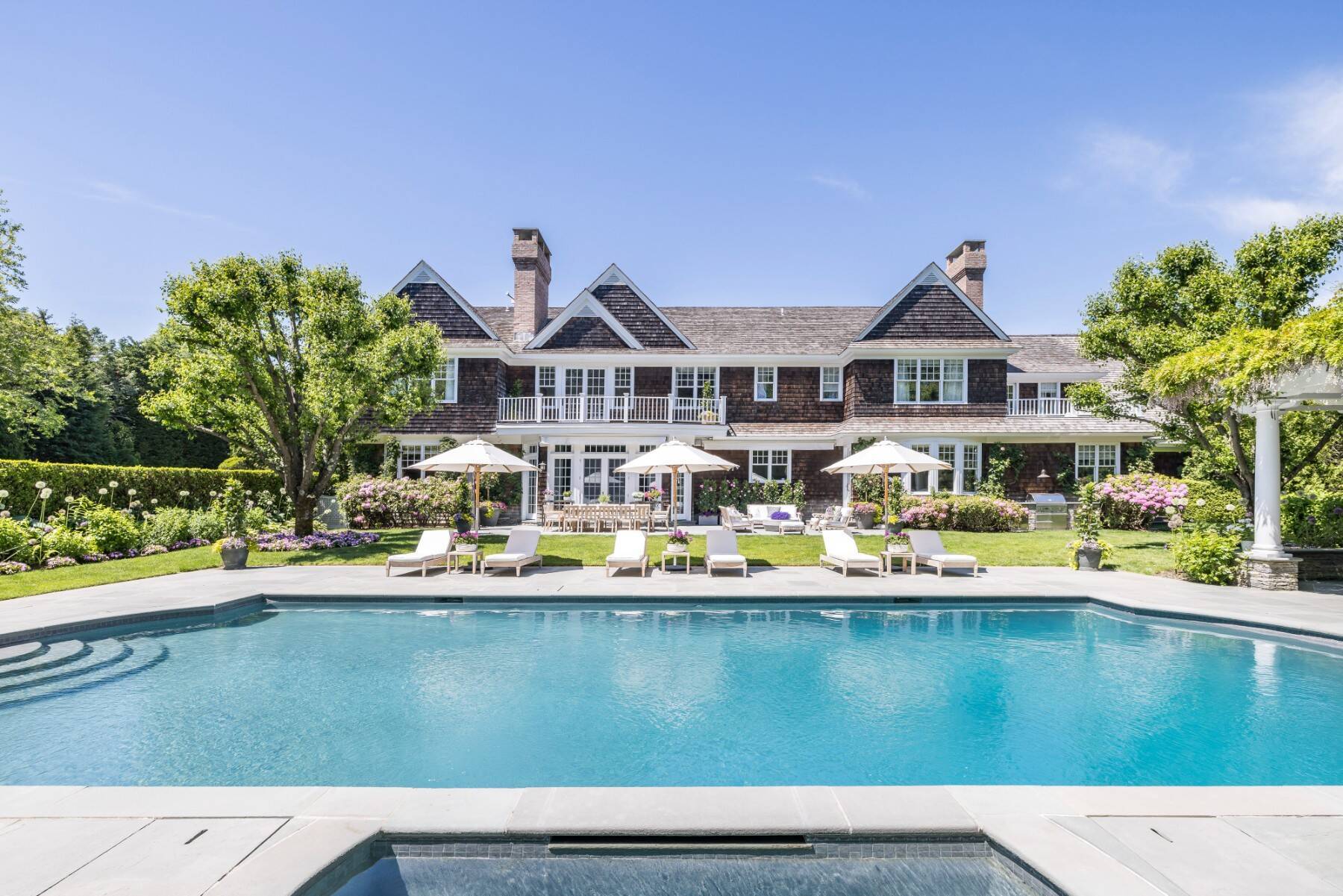 exterior back of Southampton, NY shingle-style home with pool deck 