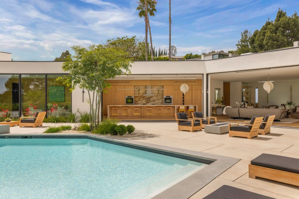 kitchen and living spaces in Beverly Hills home with retractable glass walls flowing out to the pool deck