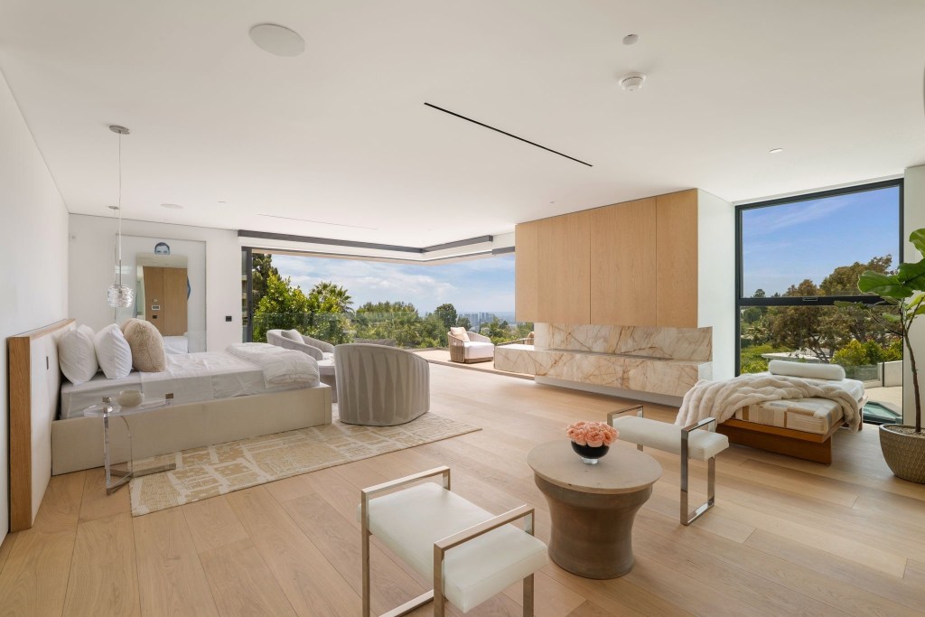 tranquil primary suite with balcony overlooking the city and marble fireplace