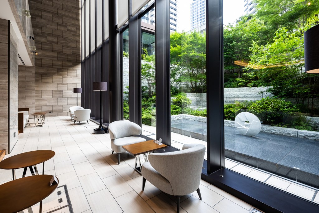 Lobby with a wall of windows looking out onto landscaping and a fountain, in Osaka, japan.