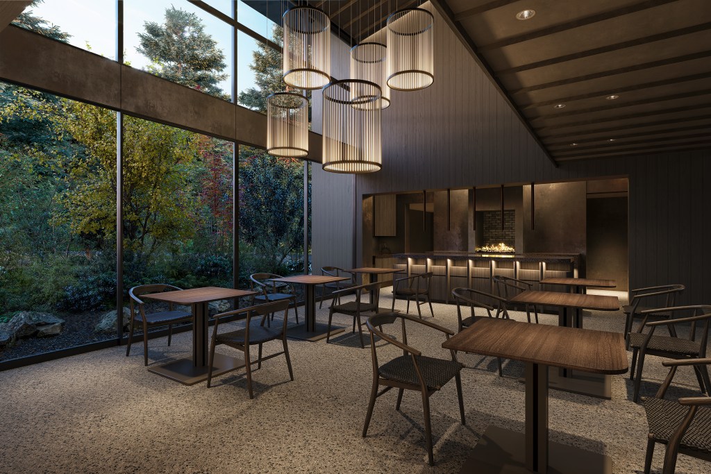 Grand lounge with a wall of windows looking out to trees at a home in Karuizawa, Japan.