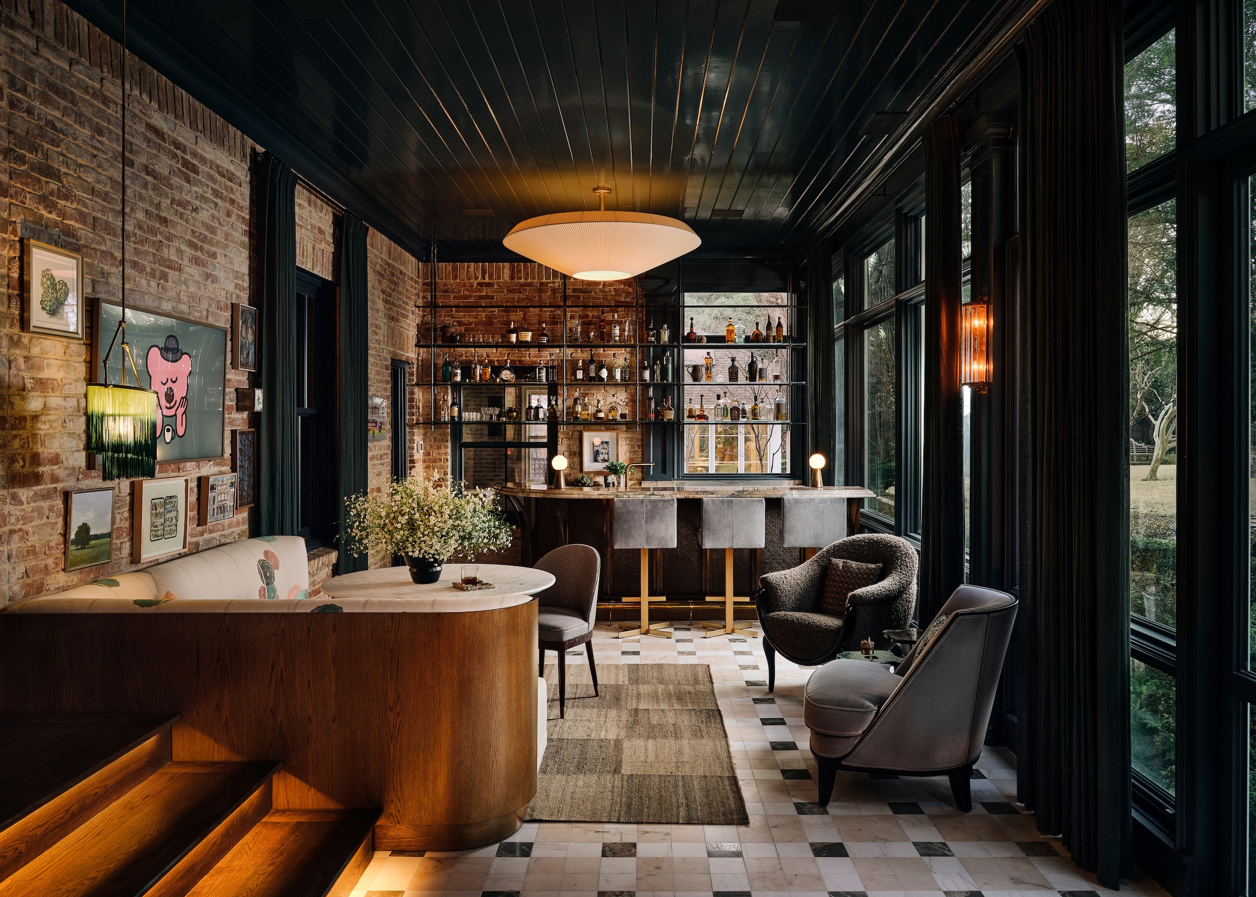 a cocktail bar with brick walls and expansive seating by Chad Dorsey Design in a Dallas private residence