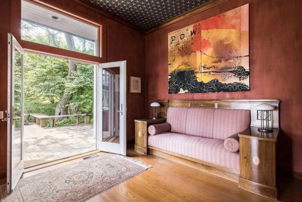sitting area in Bridgehampton, NY home with textured burgundy walls and French doors