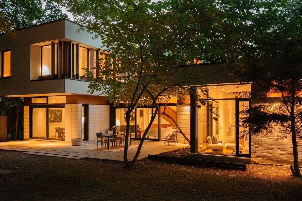 Exterior of contemporary home in Toronto with large windows and outdoor seating