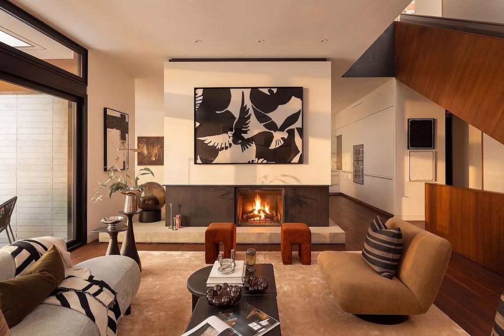 Interior of Toronto home with dramatic art piece over a fireplace and neutral-toned seating area