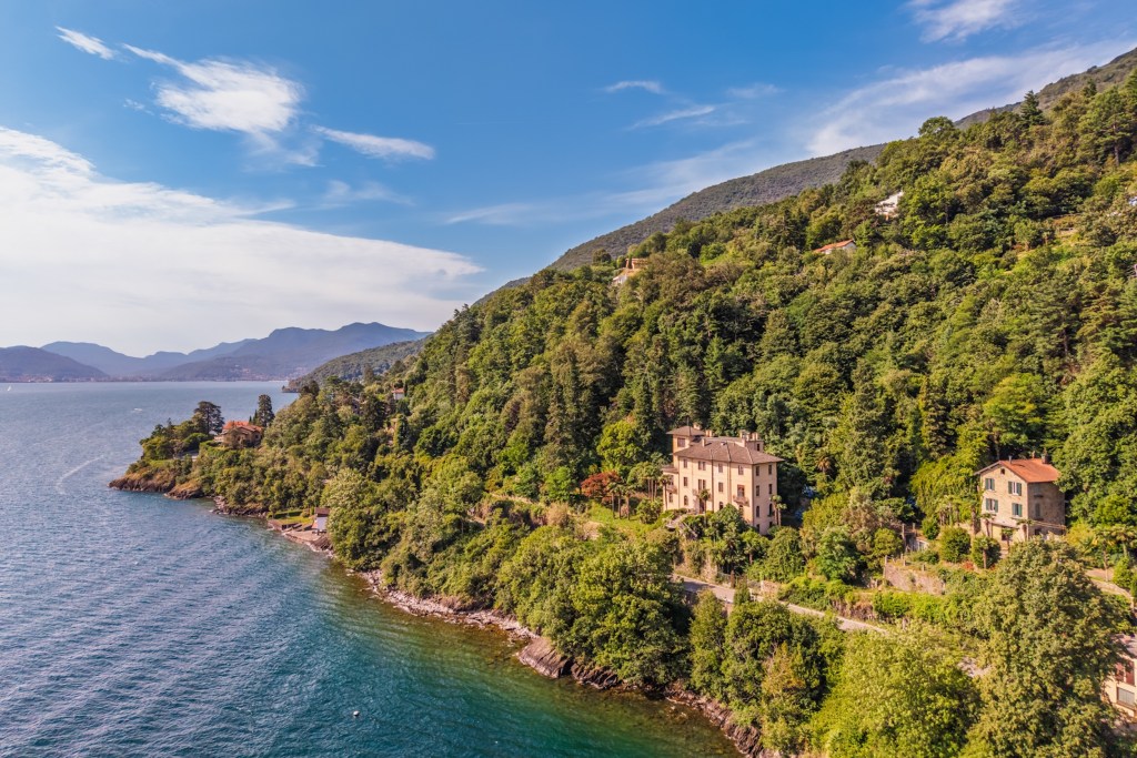 photo of a villa on Lake Maggiore in Italy, perched on a hillside overlooking the water and trees