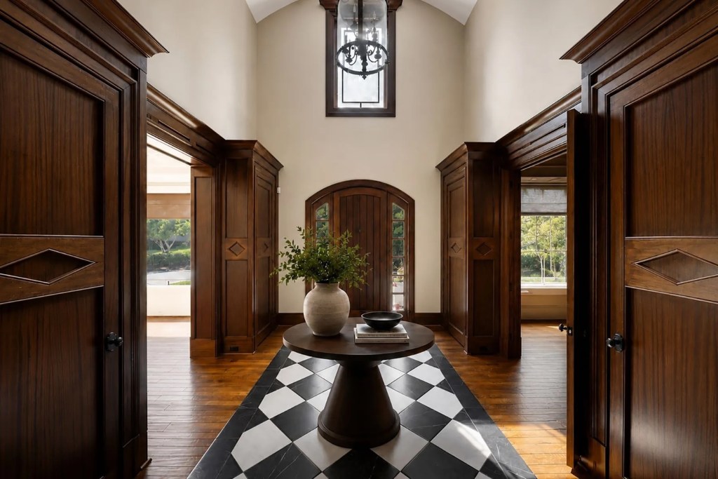 foyer in Atlanta, Georgia home featuring wood accents and doors, a dark wood central table, and black and white diagonal tile along the floor